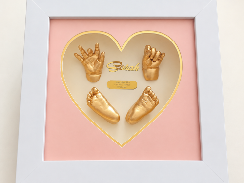 Mẫu tranh Baby Art được thiết kế với khung vuông trắng sang trọng, kích thước 30x30cm, nổi bật với mặt trái tim màu hồng nhẹ nhàng, tinh tế. Bên trong là dấu tay – dấu chân 3D của bé phủ vàng ánh kim, kết hợp cùng tên bé và thông tin ngày sinh, tạo nên tổng thể ấm áp, đáng yêu và đầy ý nghĩa. Sản phẩm phù hợp để lưu giữ kỷ niệm đầu đời của bé, trang trí không gian gia đình hoặc làm quà tặng đầy tháng, thôi nôi rất ý nghĩa